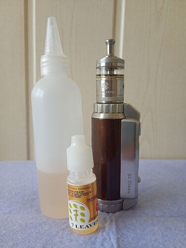 Egy vape készülék, egy nagy átlátszó palack folyadékkal és egy kisebb e-liquid flakon látható egy világos háttér előtt. (Feliratozva AI-val)