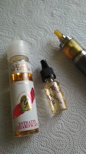 Egy e-cigaretta és két üveg e-liquid pihen egy fehér, texturált felületen. (Feliratozva AI-val)