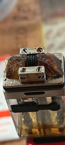 Az image egy elektronikus cigaretta (vape) fűtőbetéttel, amelyen látható a leégett vagy használt szigetelés és tekercs. (Feliratozva AI-val)