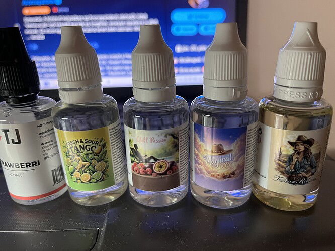 Öt különböző e-liquid üveg van egymás mellett egy laptop billentyűzete felett, különböző ízesítésekkel és címkékkel. (Feliratozva AI-val)